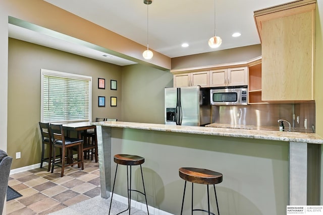 408 S 197th St, Omaha, NE 68022 - kitchen featuring appliances with stainless steel finishes, a peninsula, light brown cabinets, a breakfast bar, and recessed lighting