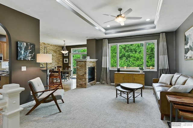 408 S 197th St, Omaha, NE 68022 - living room featuring a raised ceiling, arched walkways, a ceiling fan, crown molding, and light carpet
