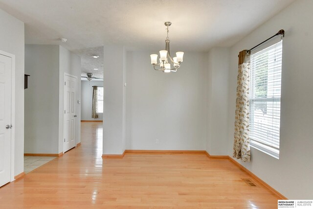 16332 Patrick Ave, Omaha, NE 68116 - spare room featuring a chandelier, light wood-style flooring, a smoke detector, and ceiling fan