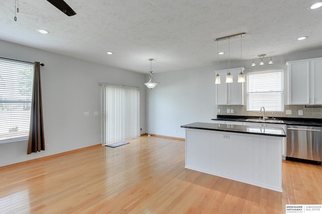16332 Patrick Ave, Omaha, NE 68116 - kitchen with dishwasher, dark countertops, light wood-type flooring, decorative backsplash, and white cabinetry