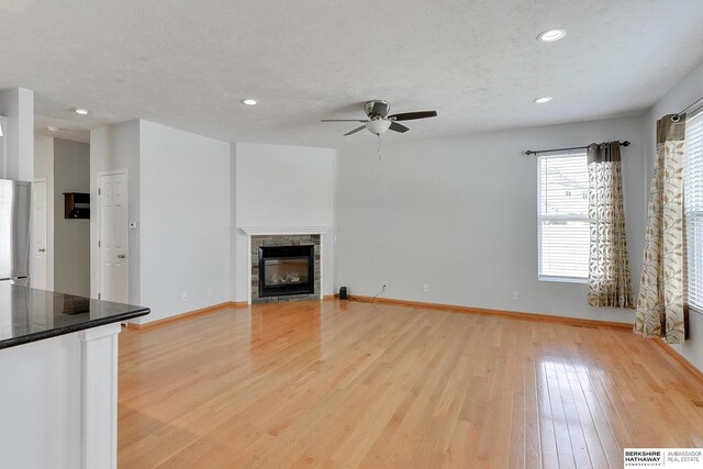 16332 Patrick Ave, Omaha, NE 68116 - unfurnished living room with a ceiling fan, light wood finished floors, recessed lighting, a fireplace, and a textured ceiling