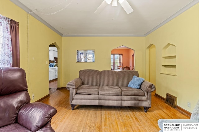 5101 Maple St, Omaha, NE 68104 - living area featuring arched walkways, built in features, wood finished floors, ornamental molding, and ceiling fan