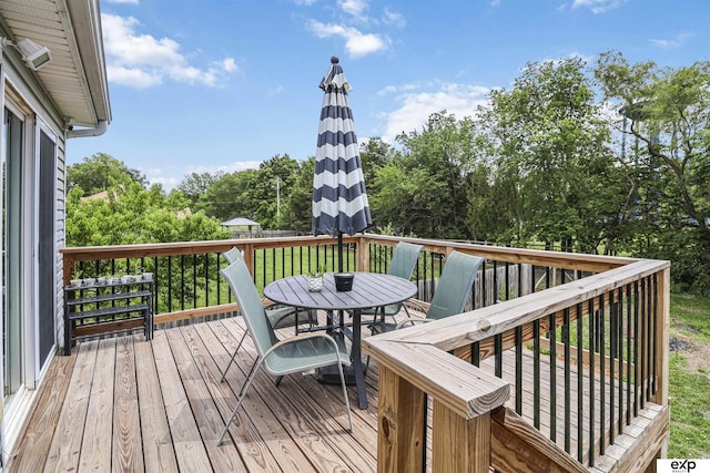 155 Vince Dr, Bennet, NE 68317 - wooden deck with outdoor dining area and view of wooded area