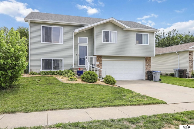 155 Vince Dr, Bennet, NE 68317 - split foyer home with an attached garage, concrete driveway, a front yard, and stone siding