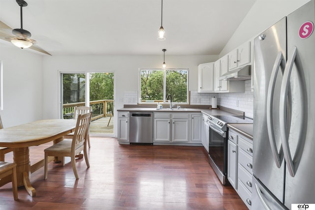 155 Vince Dr, Bennet, NE 68317 - kitchen with appliances with stainless steel finishes, under cabinet range hood, plenty of natural light, backsplash, and vaulted ceiling