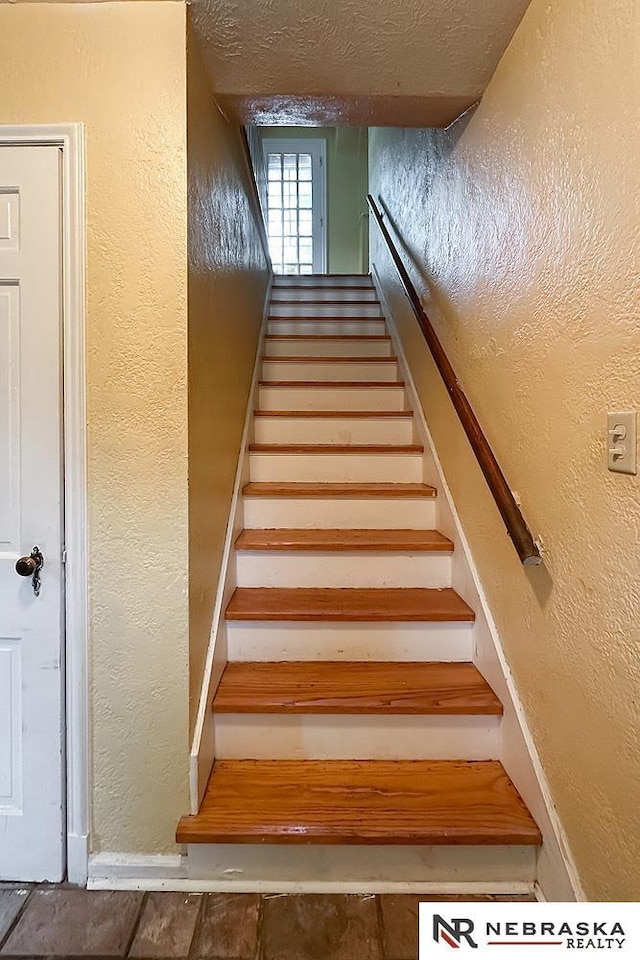 3340 N 48th Ave, Omaha, NE 68104 - staircase with baseboards and a textured wall