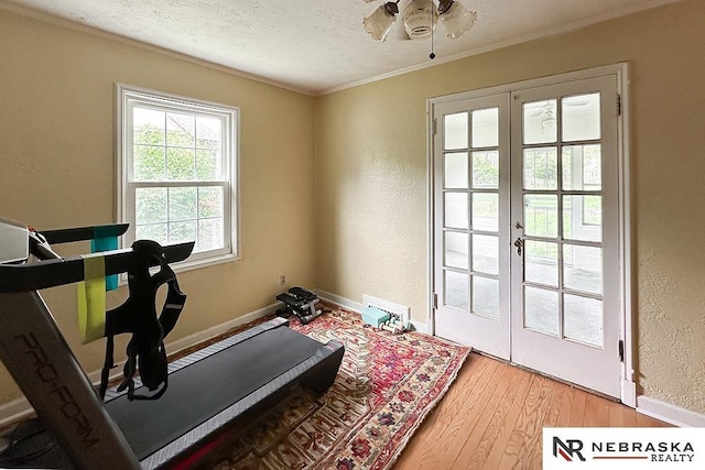 3340 N 48th Ave, Omaha, NE 68104 - exercise area with french doors, light wood finished floors, a textured wall, a textured ceiling, and crown molding