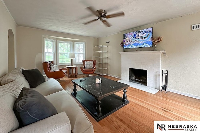 3340 N 48th Ave, Omaha, NE 68104 - living area with a ceiling fan, wood finished floors, a fireplace, and arched walkways