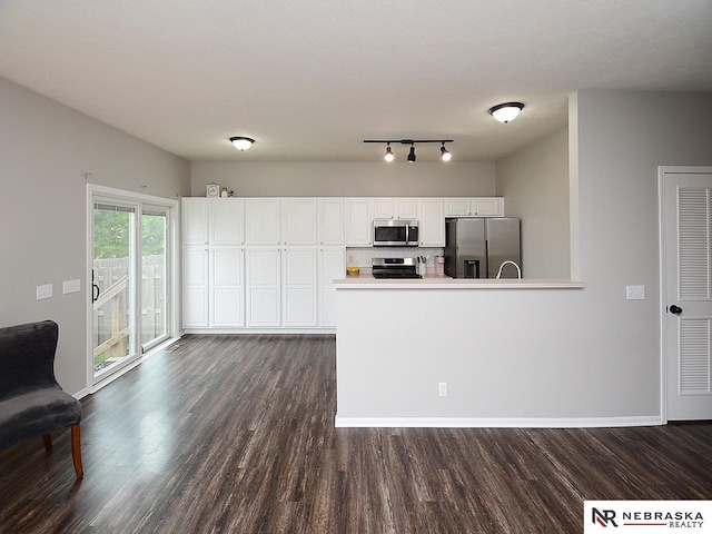 2906 Bar Harbor Dr, Bellevue, NE 68123 - kitchen featuring appliances with stainless steel finishes, dark wood-type flooring, white cabinetry, and a peninsula