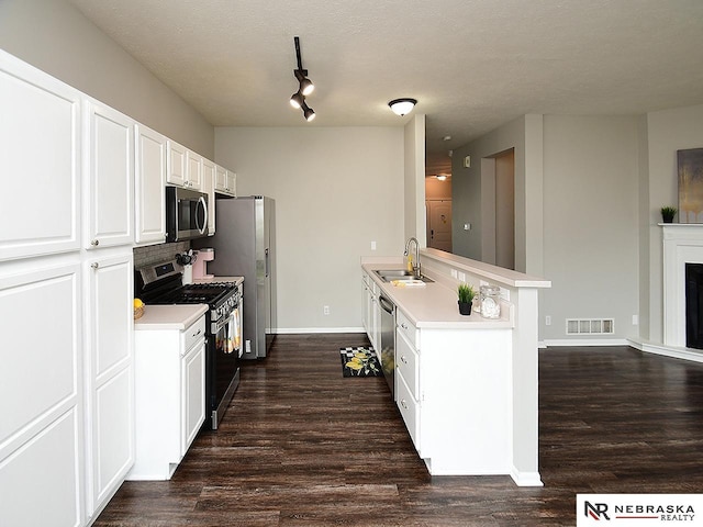 2906 Bar Harbor Dr, Bellevue, NE 68123 - kitchen featuring stainless steel appliances, dark wood-type flooring, light countertops, white cabinetry, and a textured ceiling