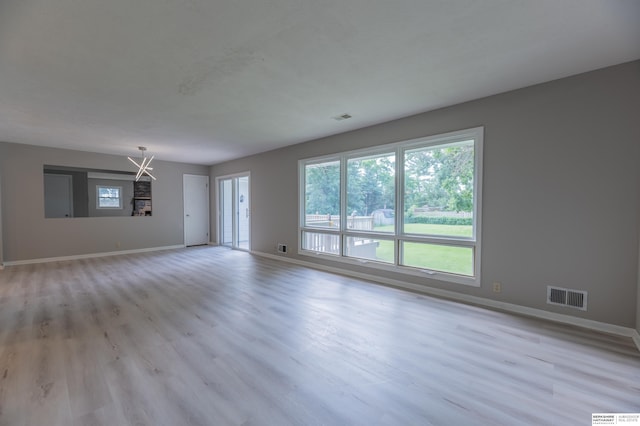 3701 Groves Rd, Bellevue, NE 68147 - unfurnished living room with light wood-style floors and a chandelier