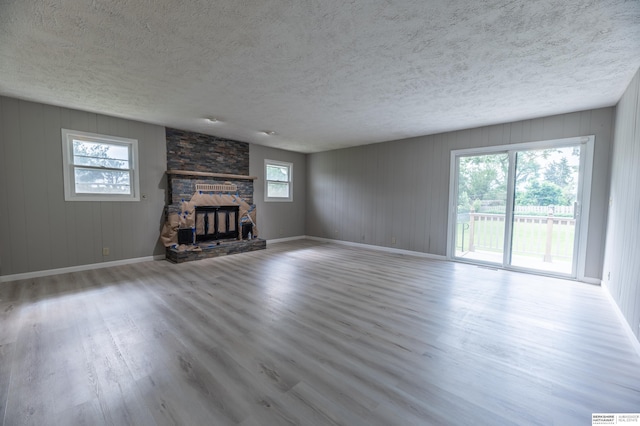 3701 Groves Rd, Bellevue, NE 68147 - unfurnished living room with wood finished floors, a fireplace, and a textured ceiling