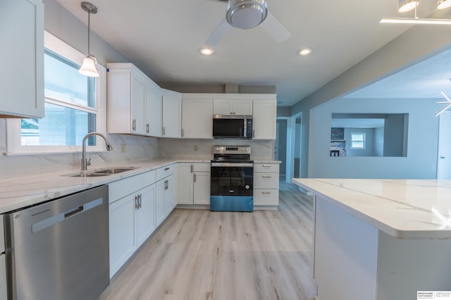 3701 Groves Rd, Bellevue, NE 68147 - kitchen featuring stainless steel appliances, ceiling fan, light wood-style floors, white cabinetry, and tasteful backsplash
