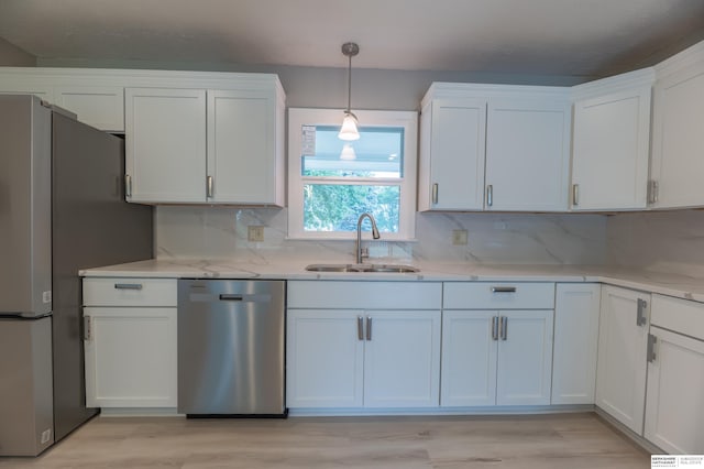 3701 Groves Rd, Bellevue, NE 68147 - kitchen with appliances with stainless steel finishes, white cabinets, decorative backsplash, and light wood-type flooring