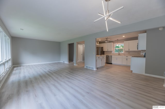 3701 Groves Rd, Bellevue, NE 68147 - unfurnished living room featuring light wood-style floors, a ceiling fan, and a chandelier