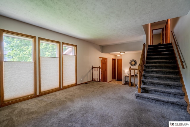12312 Decatur St, Omaha, NE 68154 - unfurnished living room with carpet flooring, a textured ceiling, and stairway