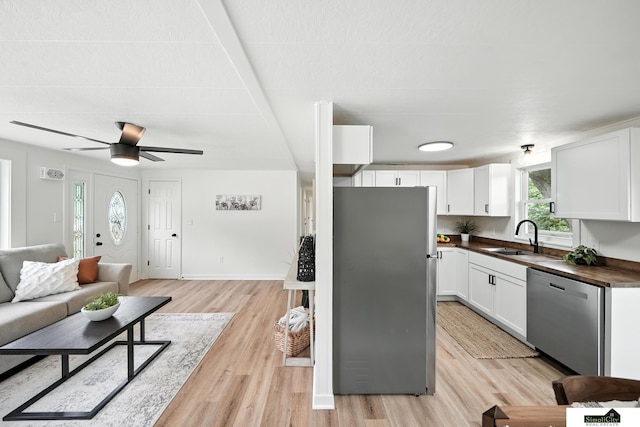 1107 N 6th St, Nebraska City, NE 68410 - kitchen featuring appliances with stainless steel finishes, open floor plan, light wood-style floors, white cabinets, and a ceiling fan