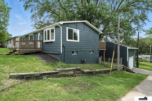 1107 N 6th St, Nebraska City, NE 68410 - view of side of home featuring a wooden deck, a lawn, board and batten siding, and a detached garage