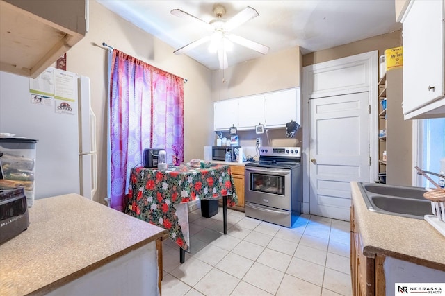 2567 Marcy St, Omaha, NE 68105 - kitchen with stainless steel appliances, ceiling fan, light tile patterned floors, white cabinets, and light countertops