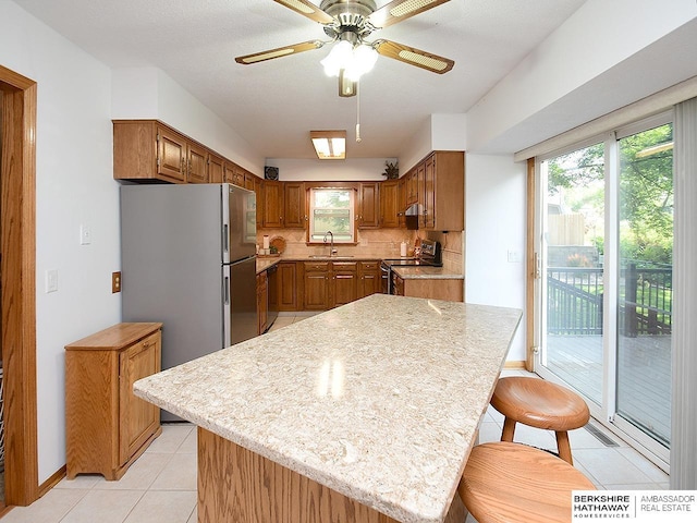 5511 S 104th Cir, Omaha, NE 68127 - kitchen with electric range oven, light countertops, and brown cabinetry
