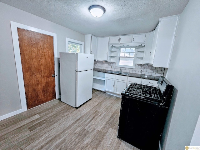 2715 S 15th St, Omaha, NE 68108 - kitchen featuring freestanding refrigerator, range with gas cooktop, open shelves, dark countertops, and light wood finished floors