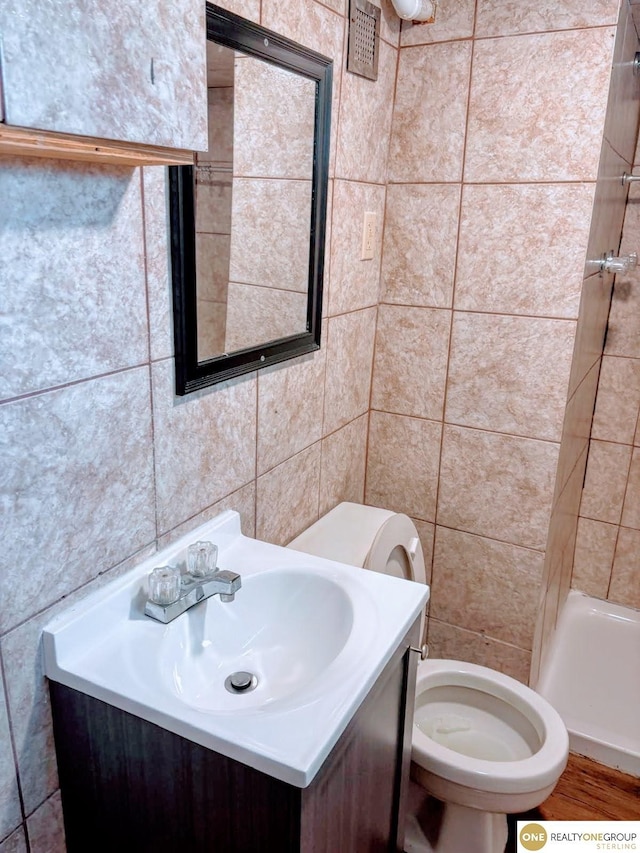 2715 S 15th St, Omaha, NE 68108 - full bath with tile walls, vanity, a shower, and wood finished floors