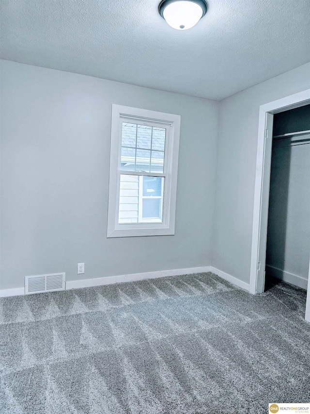 2715 S 15th St, Omaha, NE 68108 - unfurnished bedroom with a textured ceiling and carpet