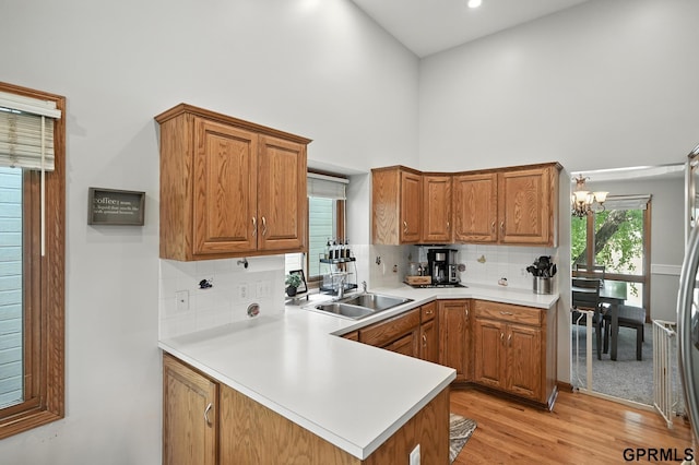 2303 N 150th Ave, Omaha, NE 68116 - kitchen with a towering ceiling, brown cabinets, light countertops, a chandelier, and backsplash