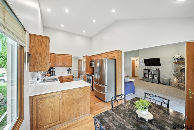 2303 N 150th Ave, Omaha, NE 68116 - kitchen with appliances with stainless steel finishes, high vaulted ceiling, a peninsula, decorative backsplash, and light wood finished floors