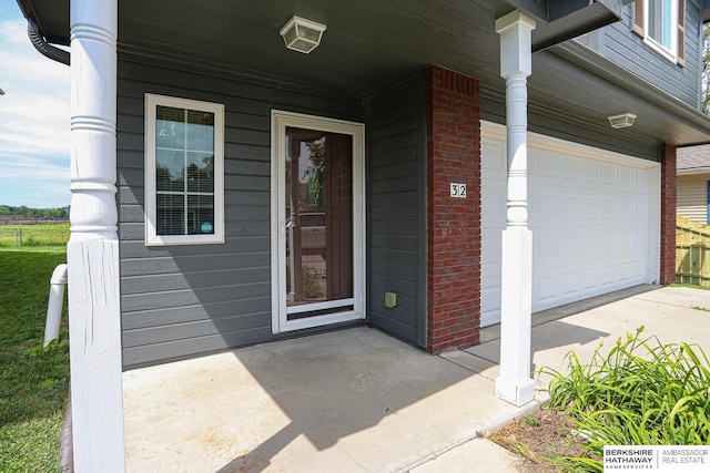 32 Huron Cir, Council Bluffs, IA 51501 - property entrance featuring brick siding, driveway, a porch, and a garage