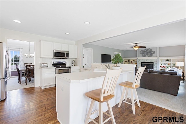 16404 Polk St, Omaha, NE 68135 - kitchen with stainless steel appliances, a breakfast bar, dark wood finished floors, ceiling fan, and recessed lighting