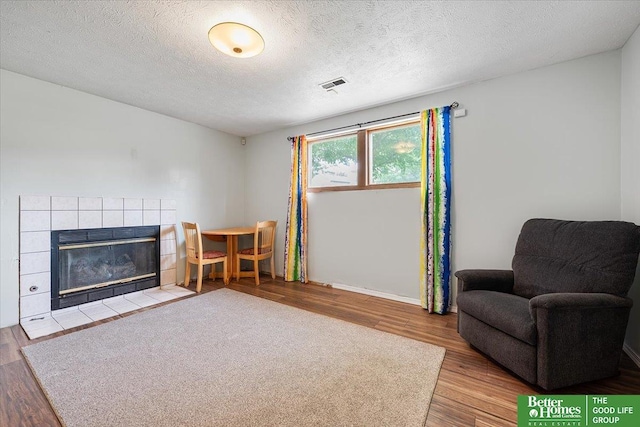 10011 S 9th Cir, Bellevue, NE 68123 - living area featuring wood finished floors, a tile fireplace, and a textured ceiling