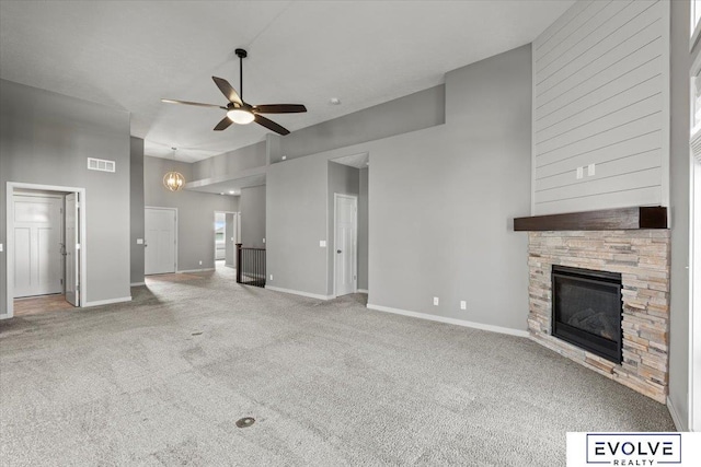 12040 S 44th St, Bellevue, NE 68123 - unfurnished living room with a ceiling fan, carpet, a stone fireplace, and a towering ceiling