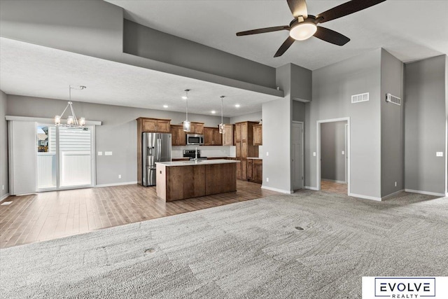 12040 S 44th St, Bellevue, NE 68123 - kitchen featuring stainless steel appliances, open floor plan, ceiling fan, a kitchen island with sink, and pendant lighting