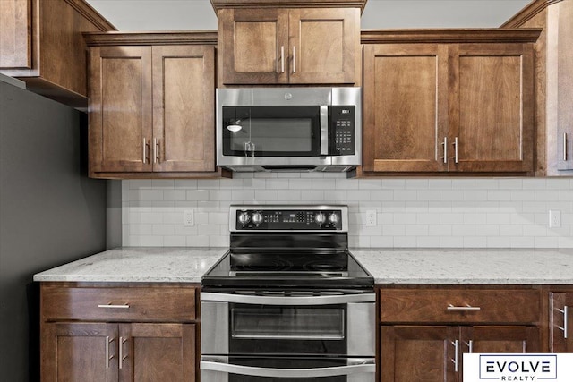 12040 S 44th St, Bellevue, NE 68123 - kitchen featuring stainless steel appliances, decorative backsplash, and light stone counters