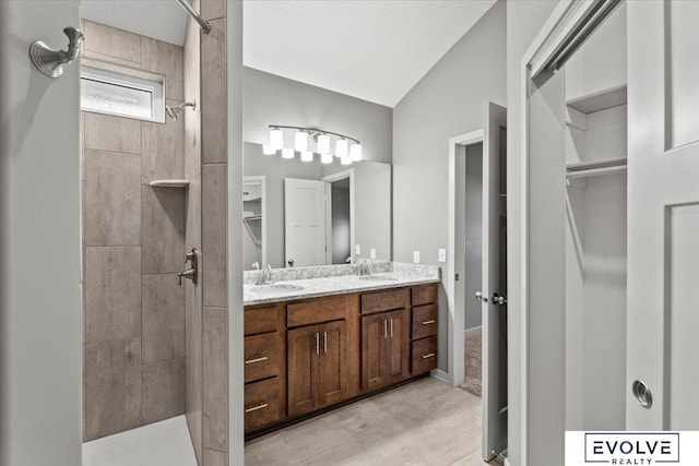 12040 S 44th St, Bellevue, NE 68123 - bathroom with tiled shower, double vanity, a walk in closet, and lofted ceiling