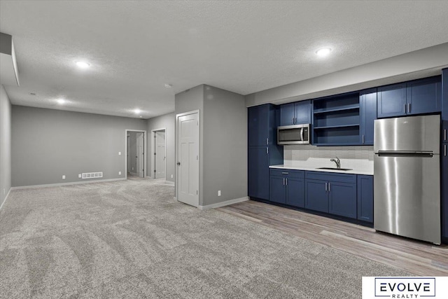 12040 S 44th St, Bellevue, NE 68123 - kitchen featuring appliances with stainless steel finishes, blue cabinets, light colored carpet, a textured ceiling, and open shelves