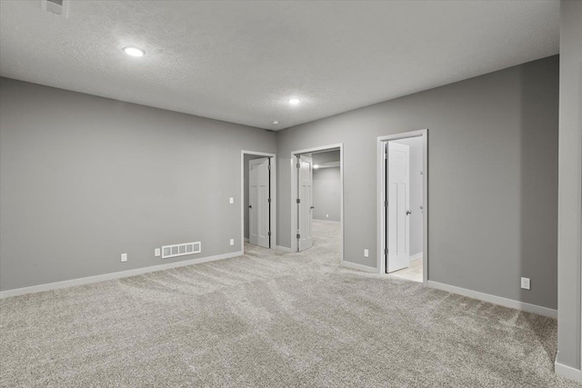 12040 S 44th St, Bellevue, NE 68123 - unfurnished bedroom with a textured ceiling, light carpet, recessed lighting, and a walk in closet