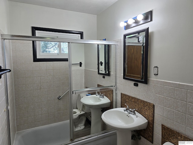 6925 Kearney Ave, Lincoln, NE 68507 - full bathroom featuring tile walls, shower / bath combination with glass door, and wainscoting