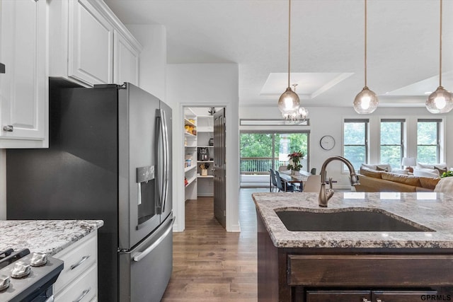 2111 Gindy Dr, Bellevue, NE 68147 - kitchen with a tray ceiling, wood finished floors, light stone counters, decorative light fixtures, and range