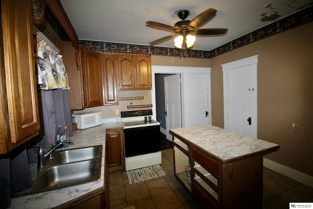 315 N Main St, Wilber, NE 68465 - kitchen featuring white appliances, a ceiling fan, light countertops, and dark tile patterned floors