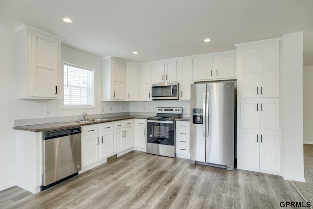 2507 Murray Rd, Plattsmouth, NE 68048 - kitchen featuring appliances with stainless steel finishes, dark countertops, light wood-style floors, and recessed lighting