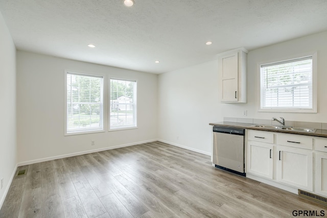 2507 Murray Rd, Plattsmouth, NE 68048 - kitchen with stainless steel dishwasher, dark countertops, light wood finished floors, white cabinetry, and recessed lighting