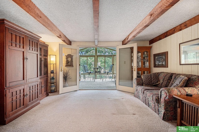 9109 Murray Dr, Plattsmouth, NE 68048 - living room featuring carpet, french doors, beamed ceiling, wooden walls, and a textured ceiling