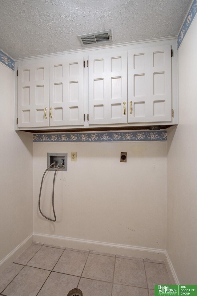 2530 S 148th St, Omaha, NE 68144 - laundry area with cabinet space, hookup for a washing machine, electric dryer hookup, a textured ceiling, and light tile patterned floors