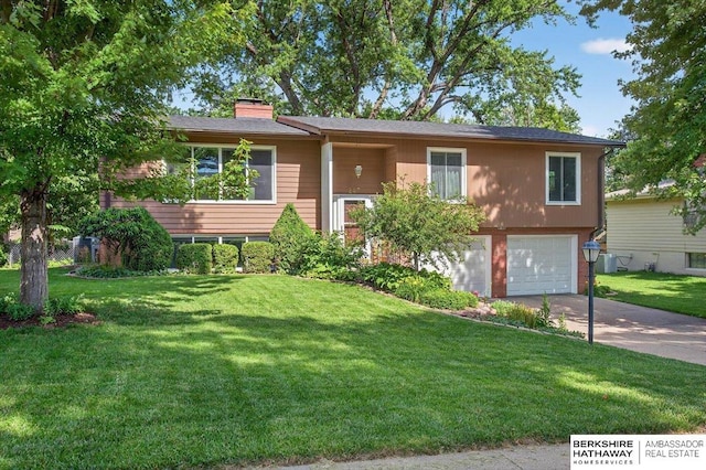 247 N 117th Ave, Omaha, NE 68154 - split foyer home with concrete driveway, an attached garage, a chimney, and a front yard