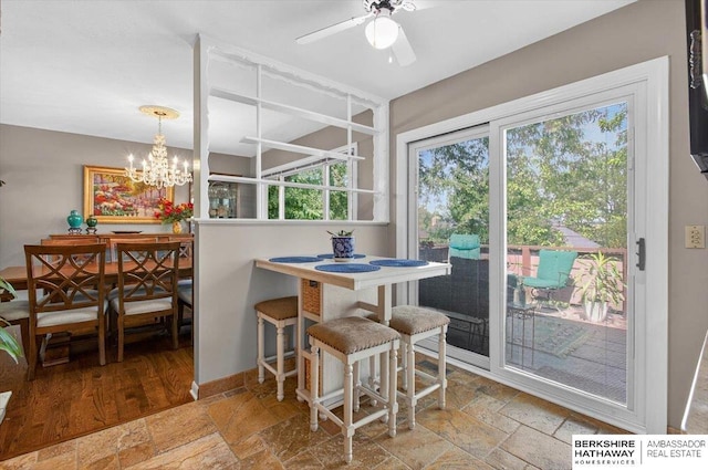 247 N 117th Ave, Omaha, NE 68154 - dining space featuring stone tile flooring, a ceiling fan, and a chandelier
