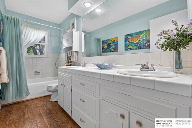 247 N 117th Ave, Omaha, NE 68154 - bathroom with double vanity, shower / bath combo, wood finished floors, decorative backsplash, and tile walls
