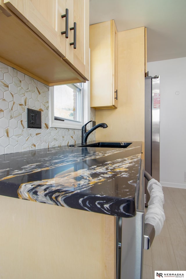 3772 F St, Lincoln, NE 68510 - kitchen with freestanding refrigerator, decorative backsplash, light brown cabinets, dark countertops, and light tile patterned floors