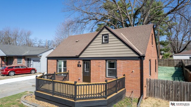 3772 F St, Lincoln, NE 68510 - rear view of house featuring brick siding, driveway, and a wooden deck